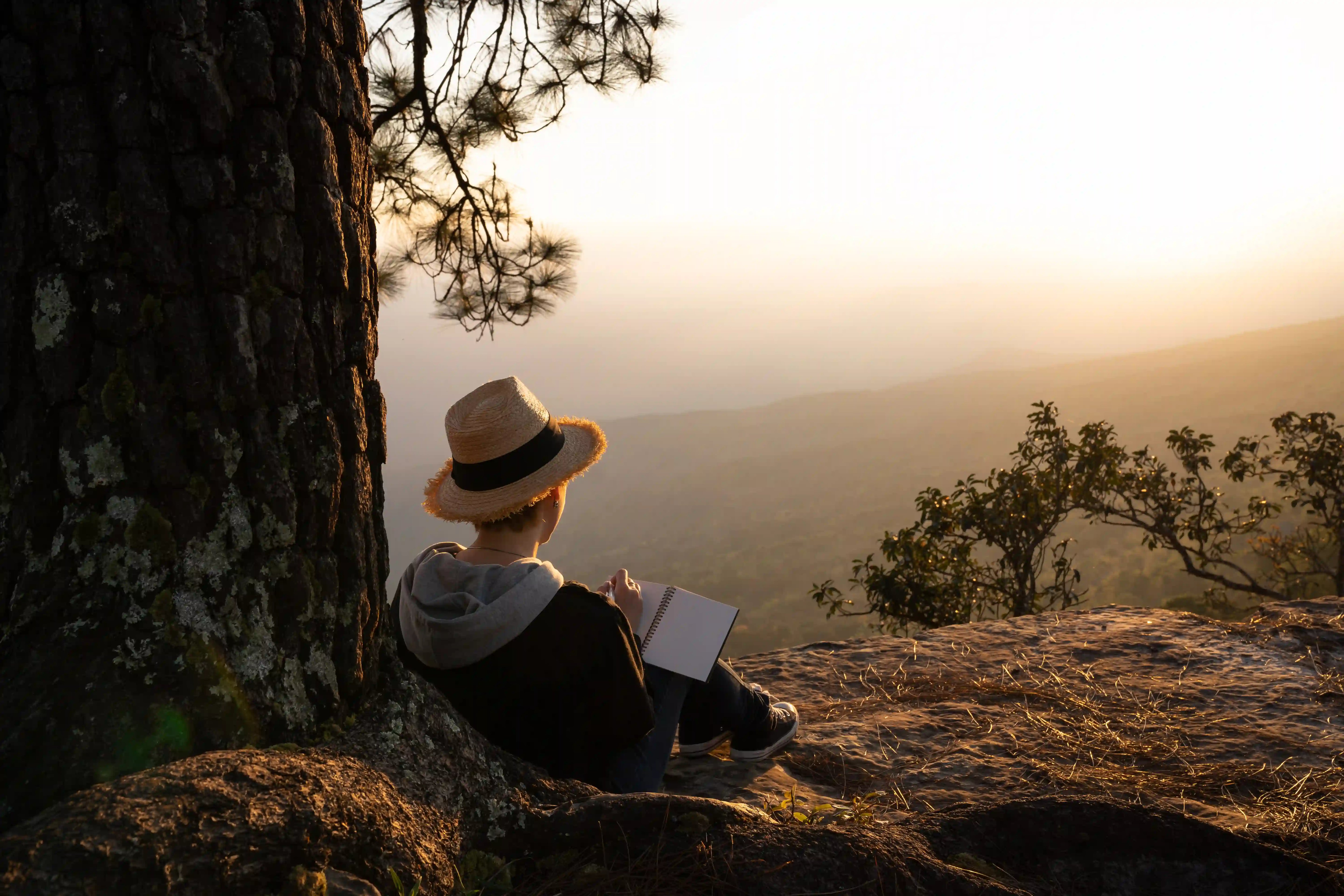 woman journalling on the mountains