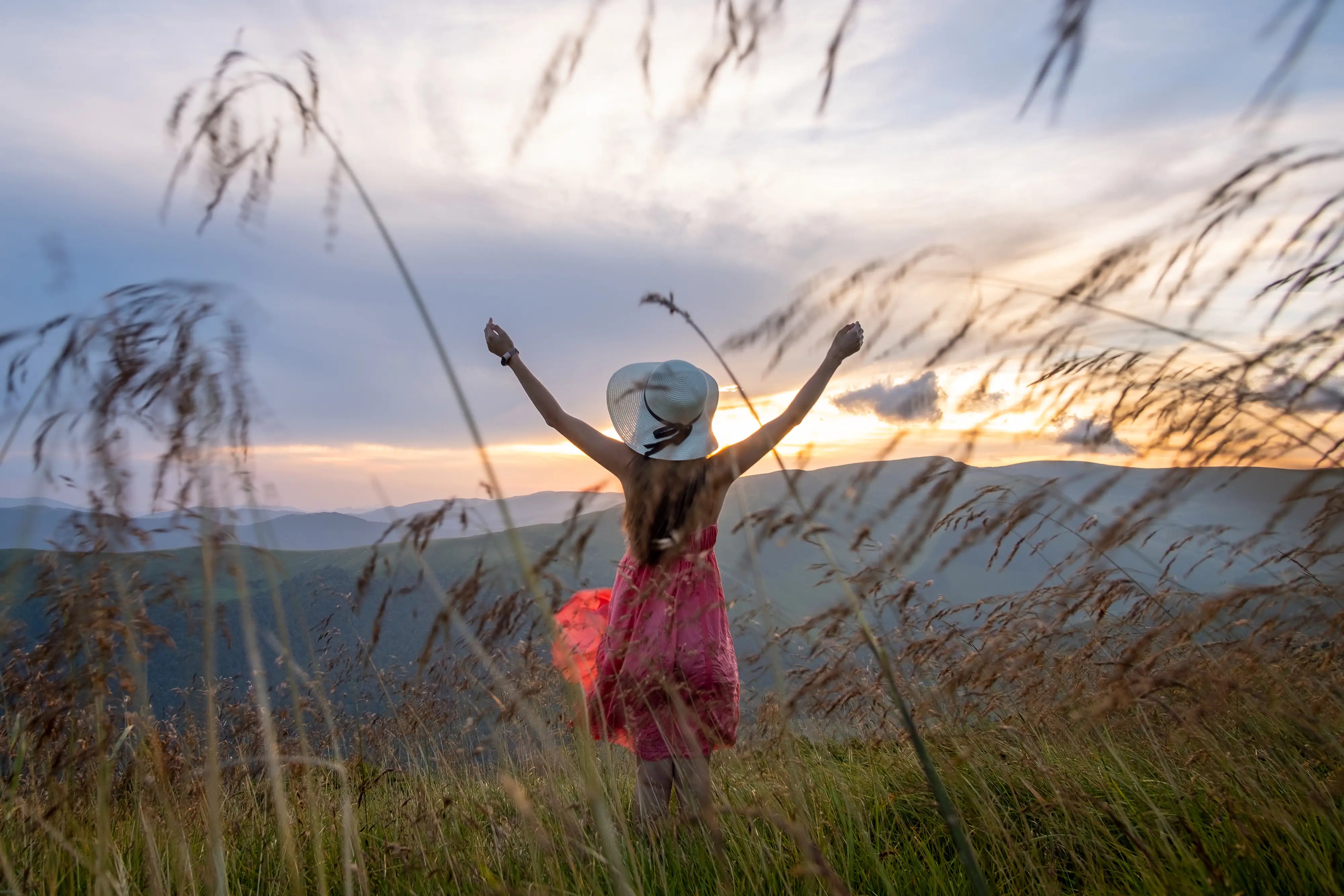 woman in red dress standing on grassy field