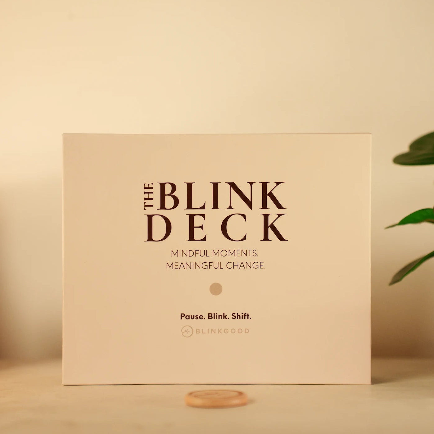 The Blink Deck packaging on a table with candles and a plant in the background
