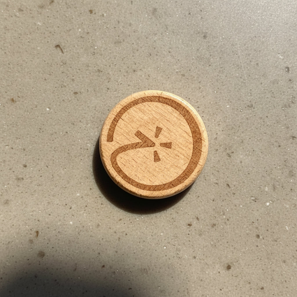 Wooden blink token with a circular design on a marble surface